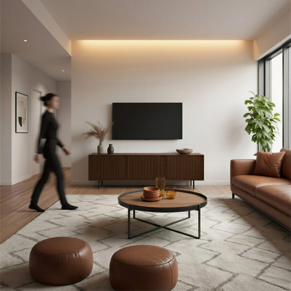 Living room with a walnut-toned Pau TV unit and a person walking past the seating area