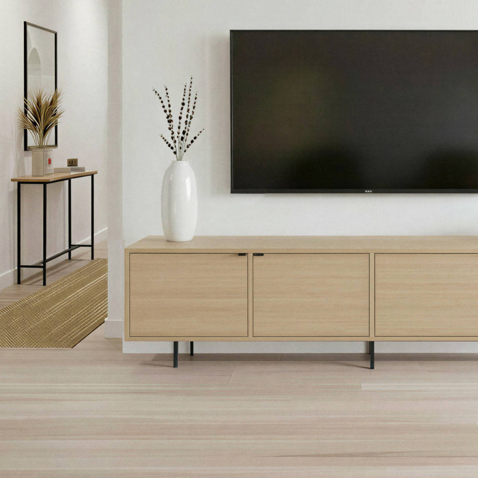 Front detail of an oak-toned Pau TV unit with smooth doors and black legs