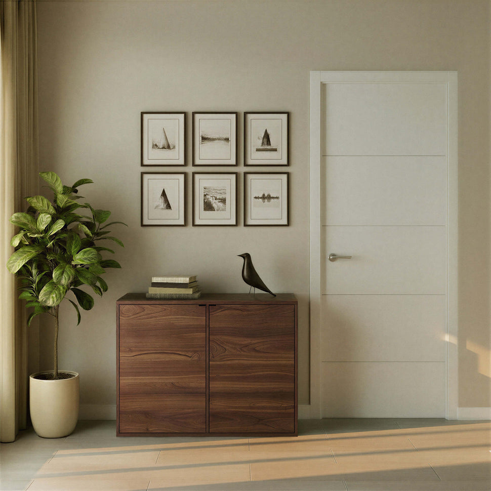 Two-door walnut-toned Pau sideboard with smooth fronts beside a plant and framed pictures