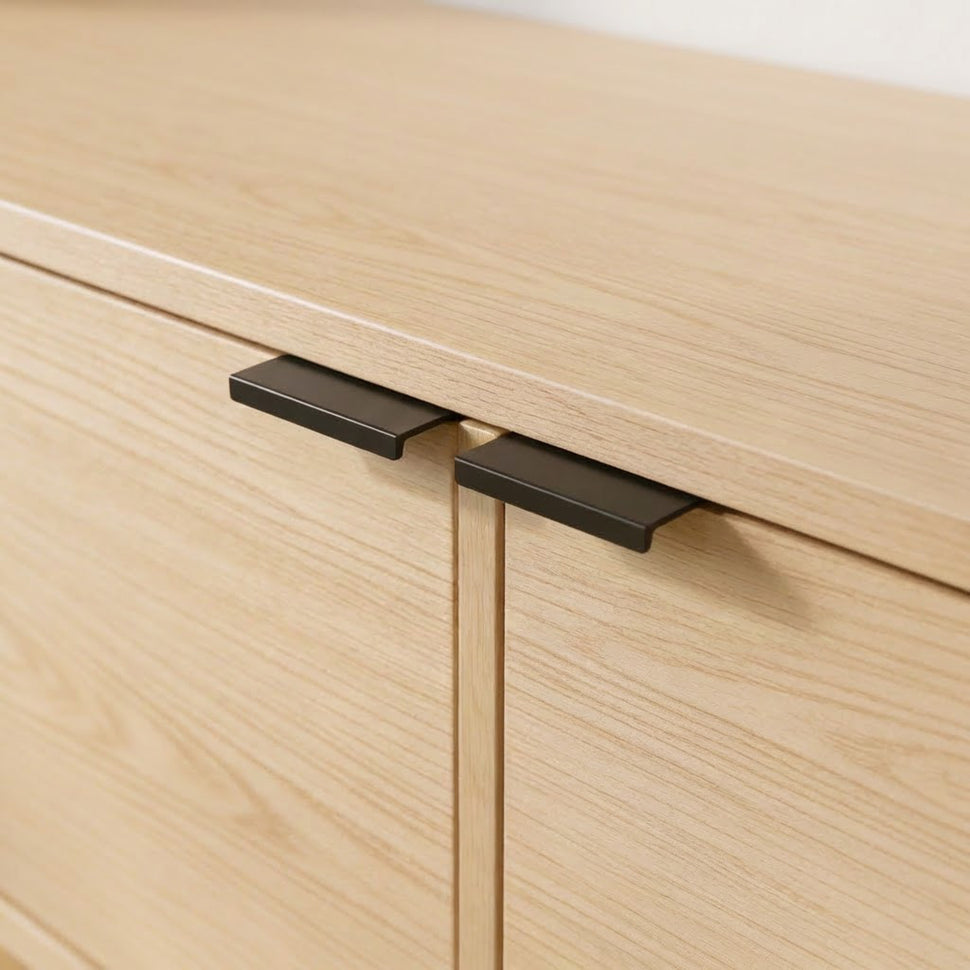 Close-up of black handles on smooth oak-toned Pau doors