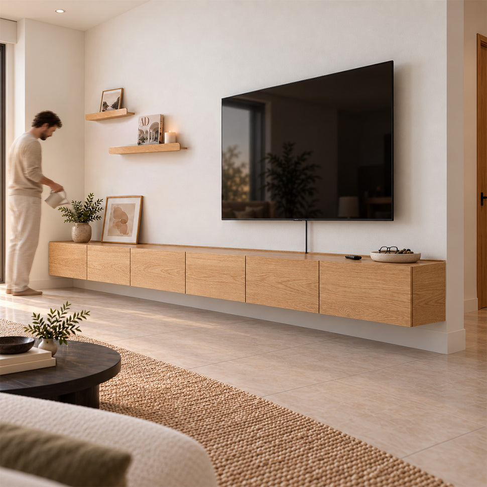 Person styling a six-module Dalea XL floating TV unit in an oak finish
