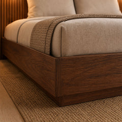 Detail of the walnut Stoa storage bed frame corner with mattress and bedding in a bedroom